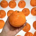 Detailed view of a realistic orange-shaped PU slow rebound squeeze toy held in hand - Mandarin / Bright Orange