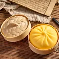 Lindo juguete blandito de pan al vapor amarillo en una mini vaporera de bambú realista - Estilo de Textura de Harina Amarilla