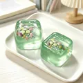 Macro detail of green maltose ice cube squishy toys with ocean shell glitters inside - Green
