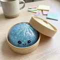 Dettaglio di un panino blu glitterato con faccina sorridente in un mini cesto a vapore - Pezzo Singolo / blu stellato