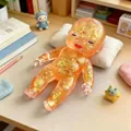 Close-up of a translucent orange glitter baby squishy toy lying on a mini pillow. - Natasha Doll / Orange Natasha Doll