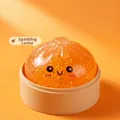 Vue détaillée du jouet spongieux en forme de brioche orange avec paillettes et sourire - Avec Base de Cuit-vapeur / Petit Pain Or Rose (Orange Vif)