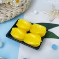 Gros plan sur quatre jouets à presser en forme de caramboles jaunes sur un plateau. - Lot de 4 / Carambole