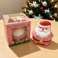 Rosa Weihnachtsmann Quetschspielzeug mit Geschenkbox in festlicher Weihnachtsatmosphäre - Rosa-Weihnachtsmann