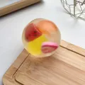 Balle anti-stress transparente avec tranches de fruits sur une planche en bois - Balle Fruits Mixtes Fait Main / 6cm
