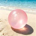 Süßer rosa durchscheinender Maltose-Stressabbau-Spielzeugball mit Wassertropfen am Strand - Eistransluzente Handgemachte Kugel / Kirschblütenrosa