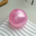 Une balle anti-stress spongieuse rose nacré faite main sur un socle blanc ondulé - Balle Rose Nacré / 6cm