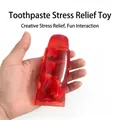 Detail of toothpaste-shaped squeeze toy with strawberry fillers for stress relief - Red Strawberry Toothpaste
