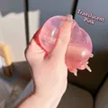 Macro view of transparent pink squishy stress relief toy being squeezed in hand - 4cm Size / Pink