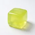 Detail eines lichtdurchlässigen gelbgrünen Maltose-Eiswürfel-Stressspielzeugs. - Orange