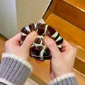 Hand drückt ein mint-braunes strukturiertes Anti-Stress-Spielzeug zur Entspannung - Minze / 1 Stück/Packung (7cm)