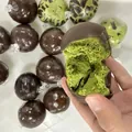 Hand hält ein grünes Matcha-Schwamm-Quetschspielzeug mit einer dunklen Schokohülle. - Matcha-Grün / 1 Stück/Packung (7cm)