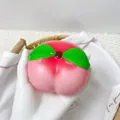 Gros plan d'un jouet spongieux en PU en forme de pêche à rebond lent tenu dans la main - Pêche Rose / 8x7cm