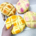 Gros plan d'une main pressant un jouet spongieux en forme de pain à l'ananas géant - Taille 16cm / Jaune