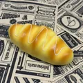 Vue détaillée d'un jouet squishy à rebond lent conçu en forme de petit pain réaliste - Pain à la Crème