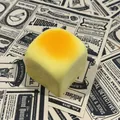 Detail view of a square bread-shaped squishy toy on vintage newspaper background - Hawaiian Bread (Partial Spray) / 6x6 Item / Milk Yellow