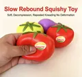 Macro view of a hand squeezing a red tomato squishy toy showing its slow rebound texture - Tomato