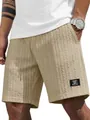 Detailansicht der beigen Herren-Zopfstrick-Shorts mit Stoffstruktur und Logo-Patch. - Khaki