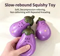Close-up of a hand squeezing a soft purple eggplant-shaped slow rebound squishy toy - Eggplant