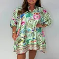 Detail view of women's V-neck dress featuring vibrant floral print on light green fabric. - XS / Dresses / Green