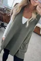 Detailansicht einer moosgrünen Strickweste mit V-Ausschnitt und zwei Seitentaschen. - Graugrün