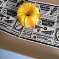 Vue macro détaillée d'un jouet squishy Bundt cake jaune sur fond de journal vintage - Donut au Pain