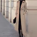 Elegant women's long camel wool overcoat with double-breasted buttons in a street setting. - Khaki