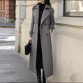 Detail showing full silhouette of a long slim grey wool coat in an urban street set. - Space Gray