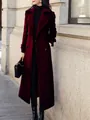 Full length view of a woman wearing an elegant long burgundy wool coat in city street - S / Tops / Burgundy