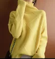 Close-up view of the intricate yellow argyle knit texture on this cozy turtleneck sweater - S / Tops / Yellow