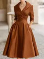 Close-up of elegant bronze satin fabric showing the wrap bodice and pleated skirt detail - Coffee