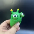 Groen monster knijpspeeltje met gele antennes en uitpuilende ogen voor stressverlichting - Starende Rups