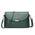 Stylish dark green leather crossbody bag for women featuring silver kangaroo logo emblem - Green