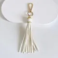 Detail view of 10cm white faux leather tassel with elegant gold-tone metal clasp - Tassel Style / 10cm / White