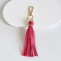 Vista dettagliata di un portachiavi con nappa in pelle rosa e una chiusura dorata - Modello a nappe / 10cm / Rosso