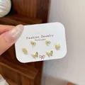 Elegant set of golden butterfly and bowknot stud earrings displayed on a white jewelry card - Butterfly Jewelry Set / Gold