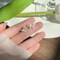 Elegant iridescent butterfly stud earrings featuring a shimmering laser finish design - Butterfly Stud Earrings / Iridescent White