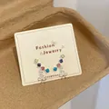 Colorful rhinestone earrings with bow dangles on a jewelry card display. - Colorful Zirconia Bow Style (GSW7)