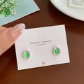 Vintage green oval stud earrings with textured silver borders on white display card - Green Rhinestone Oval Style (GSW4)