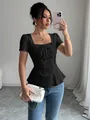 Detalle de un top de encaje negro con cuello cuadrado, lazo y bajo con volantes - S / Tops / Negro