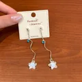Elegant silver-toned wavy line star drop earrings with ocean blue crystal accents - Tassel Star Style