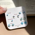 Seven-day jewelry set featuring blue hearts, flowers, and smiley face stud earrings on card - Blue Flower Sea Style (HHE003)