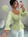 Detalle de blusa verde claro de estilo francés con textura, lazo en el cuello y peplum - S / Tops / Verde