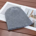 Detailed macro view of a grey ribbed knit beanie placed on a minimalist magazine. - High Elasticity / Light Gray