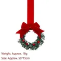 Decorative small green Christmas wreath featuring a large red velvet bow and berries - Dark Red Velvet Style