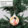 Vintage style round wooden snowman ornament hanging on green Christmas tree branch - Cartoon Snowman