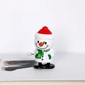 Nahaufnahme eines aufziehbaren Schneemann-Spielzeugs mit rotem Hut - Schneemann