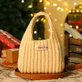 Beige gestrickte Weihnachtsgeschenktüte mit LibreJon-Label in festlicher Umgebung - Knitted champagne handbag