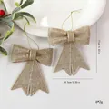 Deux nœuds de Noël dorés pailletés avec dimensions indiquées. - 2 Pièces/Pack / Champagne