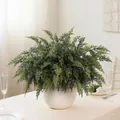 Lush artificial cedar branches in a round white ceramic vase on a dining table. - Set of 24 / Green